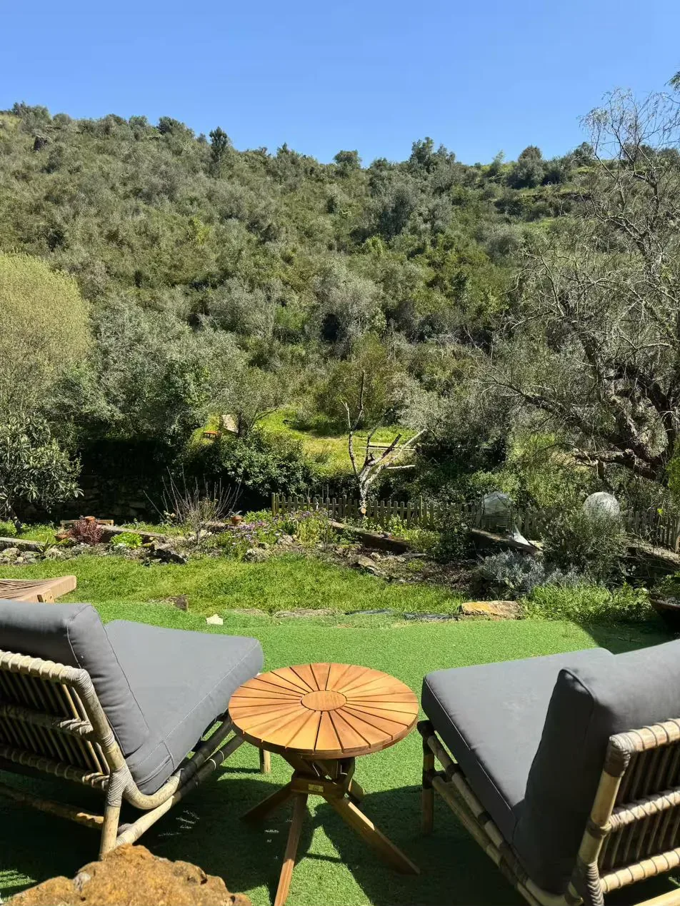 Casinha terrace — rattan chairs facing the valley and hills